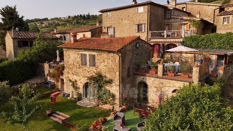 The hamlet from above, with a terrace and a white umbrella on the upper house