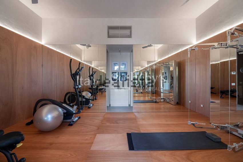 A gym with wood walls, mirrors, an exercise ball, and weight machines